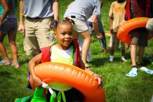 Girl with inner tube playing summer games